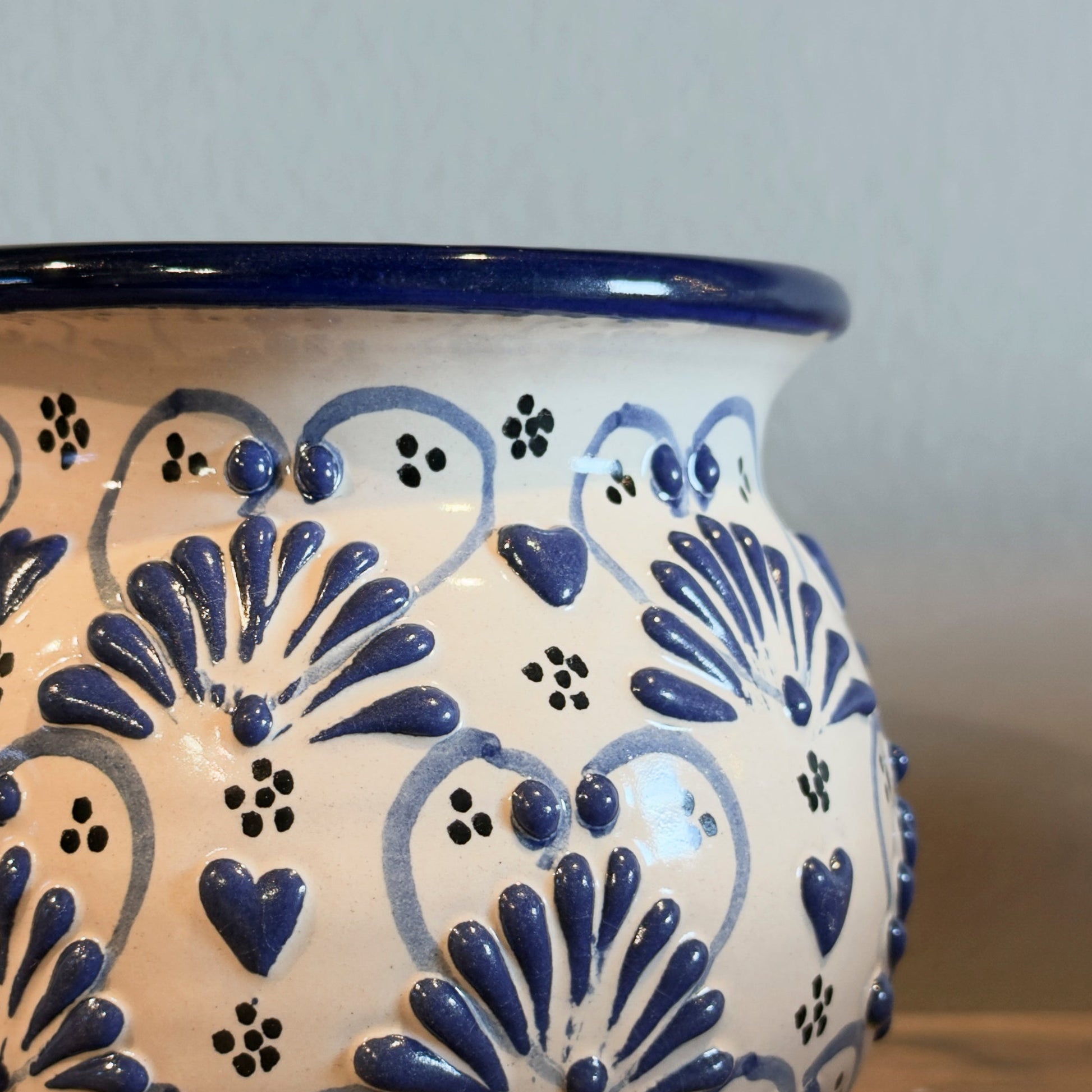 Ceramic pot with blue floral patterns on a wooden surface